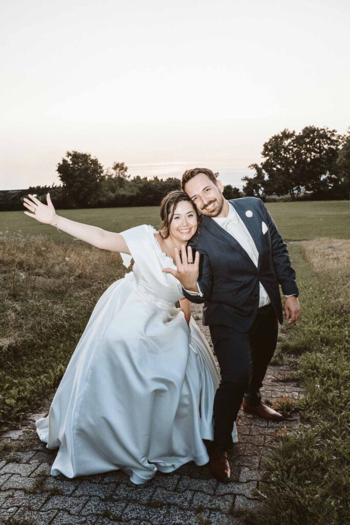 Brautpaar im Abendlicht beim Feiern, fröhliche Pose und ausgelassene Stimmung bei Sonnenuntergang in Böblingen.