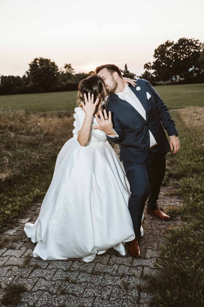 Brautpaar küsst sich bei sanftem Abendlicht während des Sonnenuntergangs in Böblingen, umgeben von natürlicher Landschaft.
