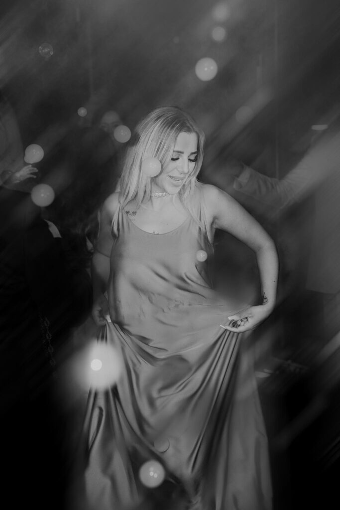 Freundin tanzt ausgelassen auf der Hochzeitsparty in Böblingen, festgehalten in einer stimmungsvollen Schwarz-Weiß-Aufnahme mit Licht- und Nebeleffekten.