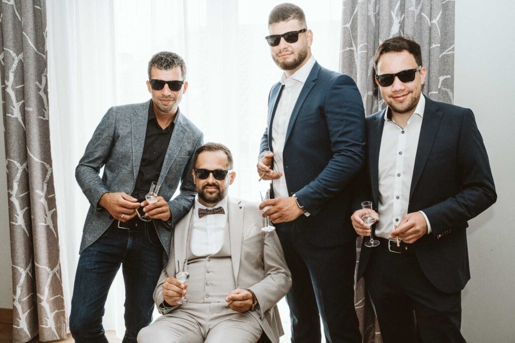 Groom Squad: Bräutigam mit seinen Trauzeugen in stilvollen Anzügen und Sonnenbrillen beim Getting Ready.
