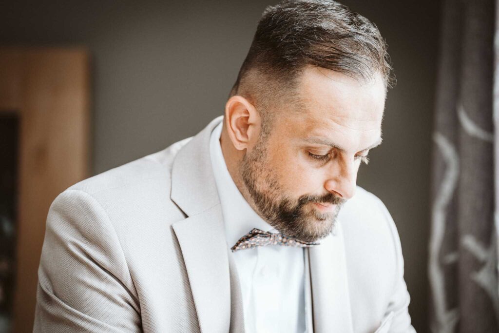 Bräutigam liest eine emotionale Nachricht beim Getting Ready in Breisach am Rhein.