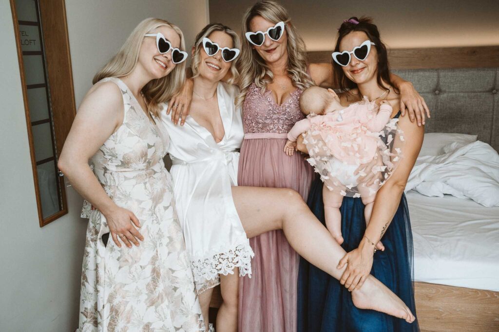 Braut und ihre Freundinnen beim Getting Ready mit Sonnenbrillen – fröhlicher Hochzeitsmoment in Breisach am Rhein