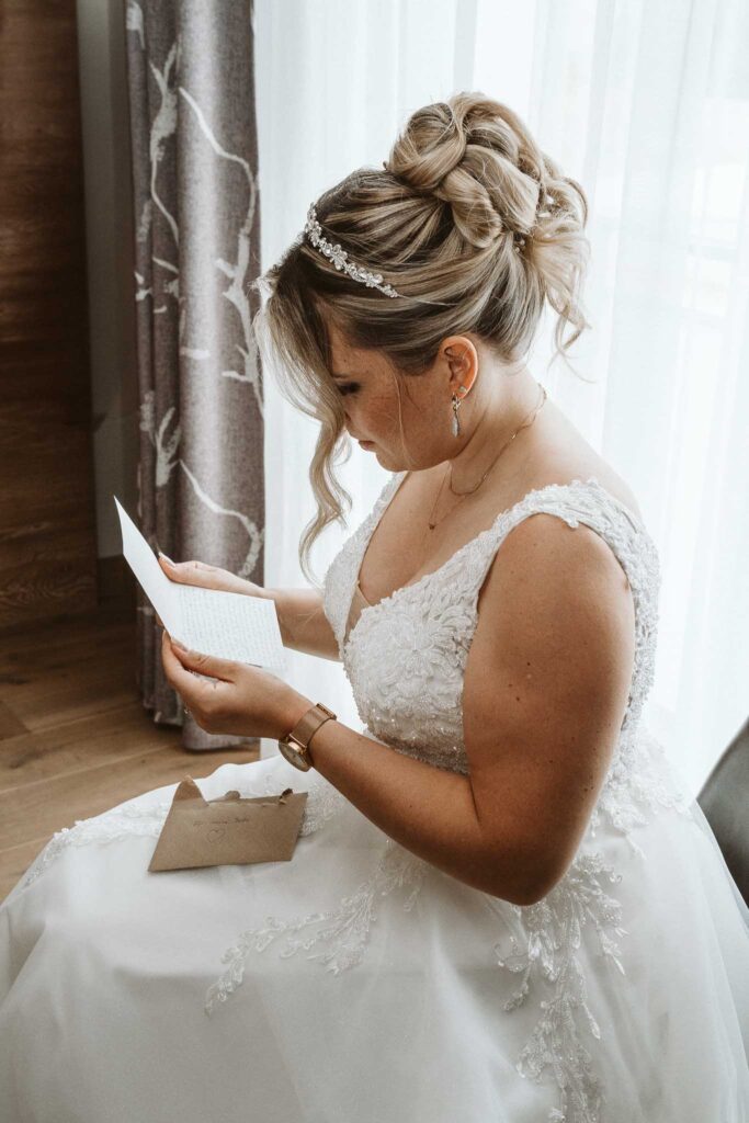 Braut liest emotionale Nachricht ihres Bräutigams beim Getting Ready in Breisach am Rhein.