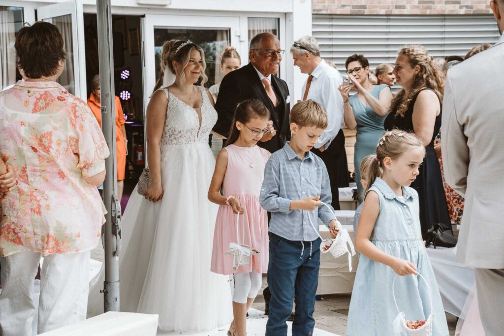 Braut betritt gemeinsam mit ihrem Vater und den Blumenkindern die freie Trauung in Breisach am Rhein.