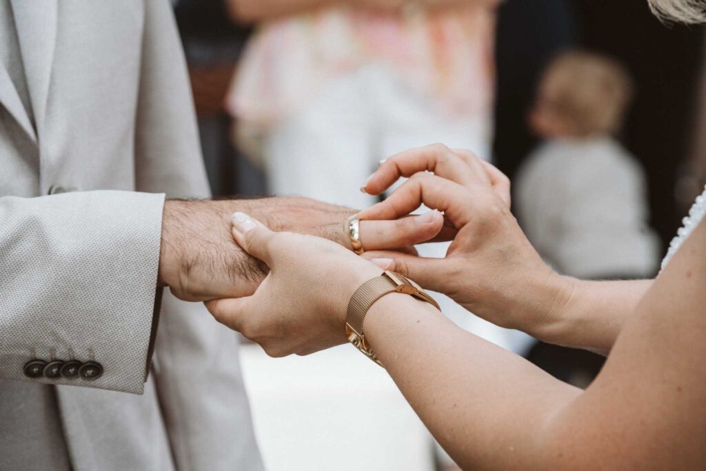 Braut steckt dem Bräutigam während der Trauung in Breisach am Rhein den Ehering an.