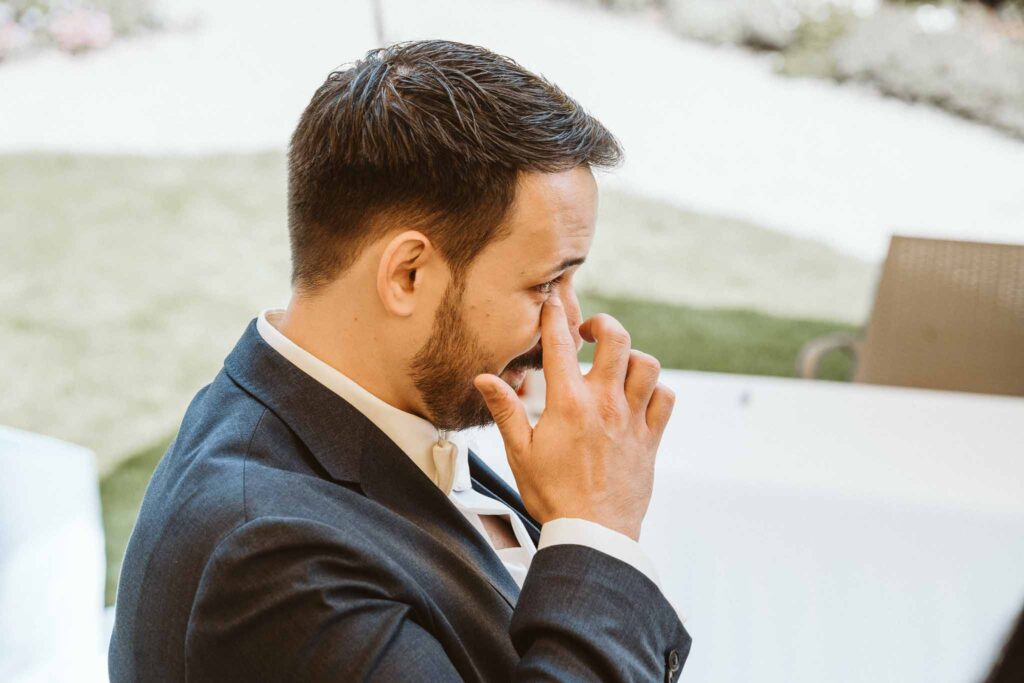 Emotionaler Moment während der freien Trauung, bei dem die Braut dem Bräutigam eine Träne aus dem Gesicht wischt.