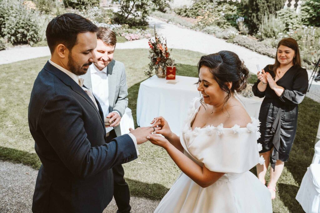 Brautpaar tauscht Ringe während der freien Trauung im Schlossgarten des Residenzschlosses Ludwigsburg.